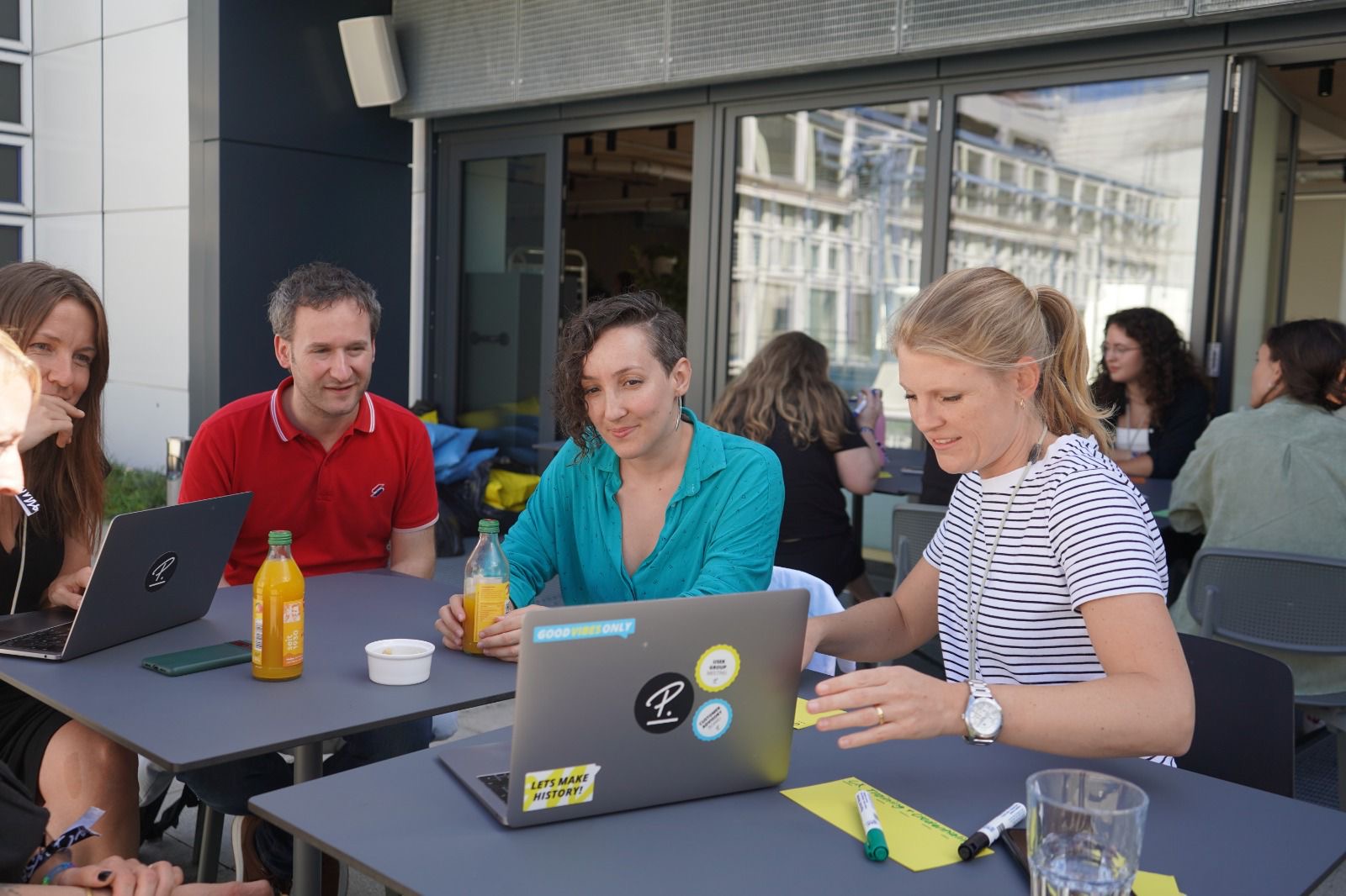 Laura collaborating with team members at an outdoor workspace
